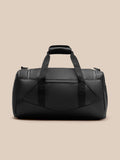 Core Holdall in black with padded top handle and sturdy webbing straps, front view against a beige background