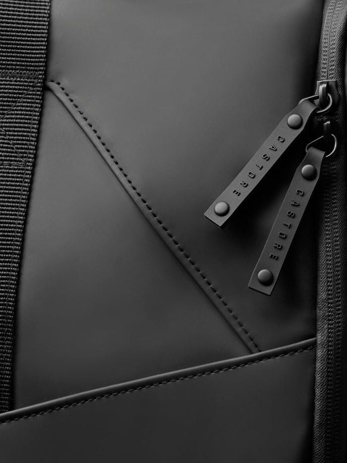 Detail of black Core Holdall zipper pulls with branded CASTORE tabs