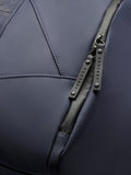 Detail of navy holdall fabric with exposed zipper and branded pulls.