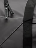 Detail of Core Holdall zipper pull on a black PU bag with a textured strap