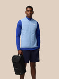 Male model wearing a light blue puffer vest holds the black Active Boot Bag.