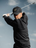 Male golfer wearing black Golf Pinnacle Performance Hoodie during a golf swing outdoors