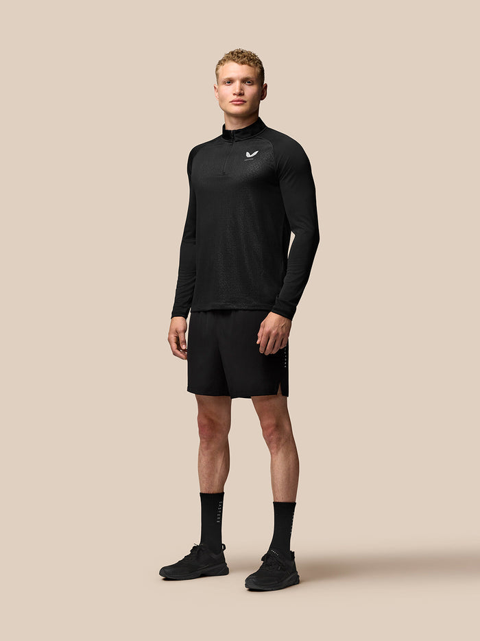 Male model wearing black Adapt Training 6 inch stretch shorts with elastic waistband and side pockets