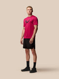 Full-body view of a male model wearing a pink Adapt Training T-Shirt with a wings graphic on the chest and black shorts
