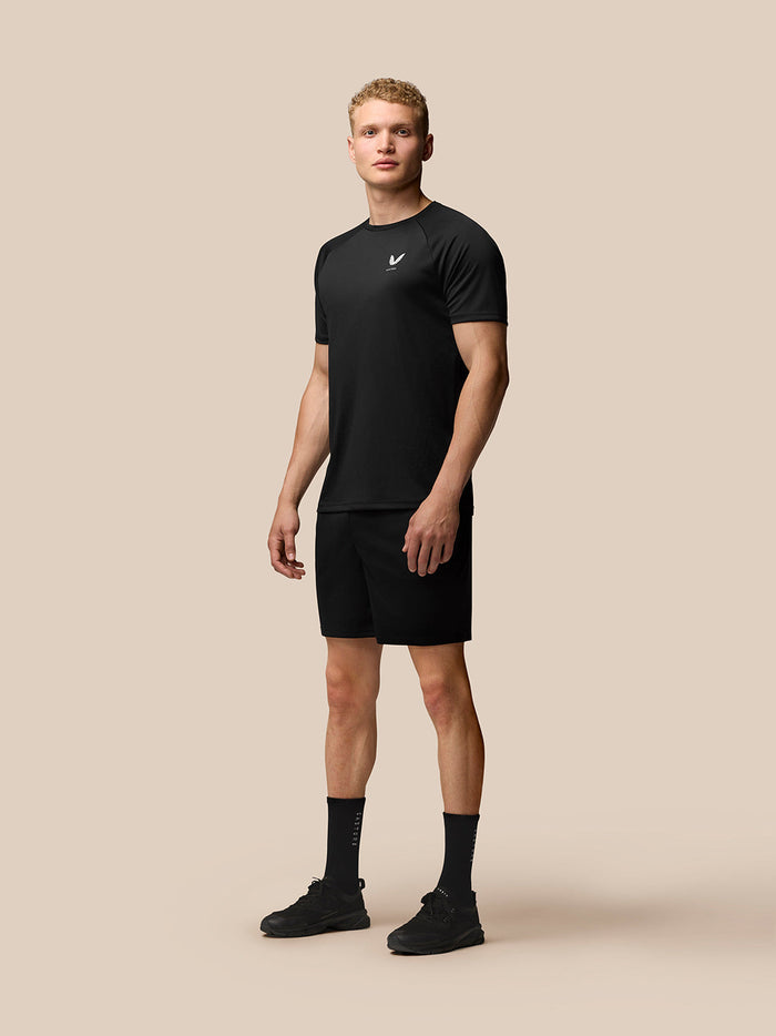 Front three-quarter view of a man in black Adapt Training T-Shirt with Castore logo on the left chest