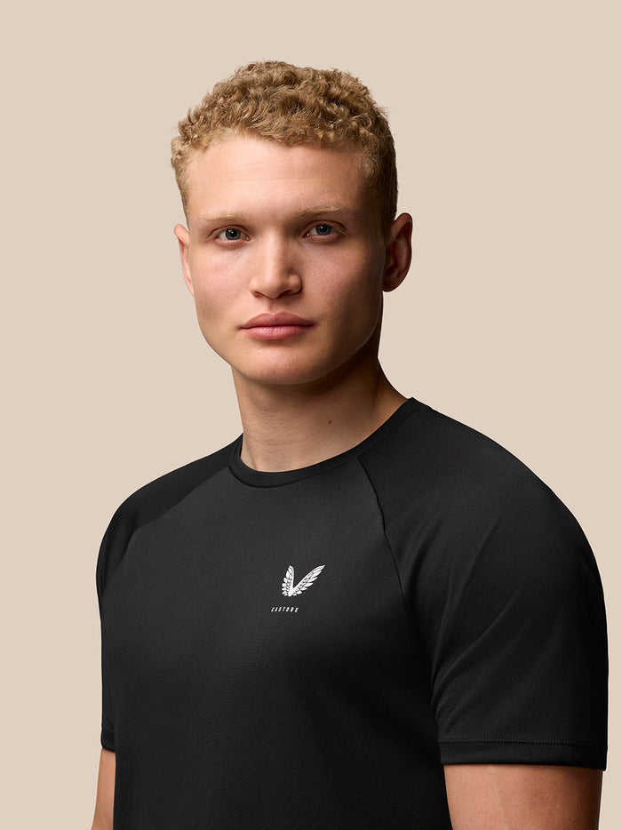 Model wearing Adapt Training T-Shirt in black with Castore logo on the left chest