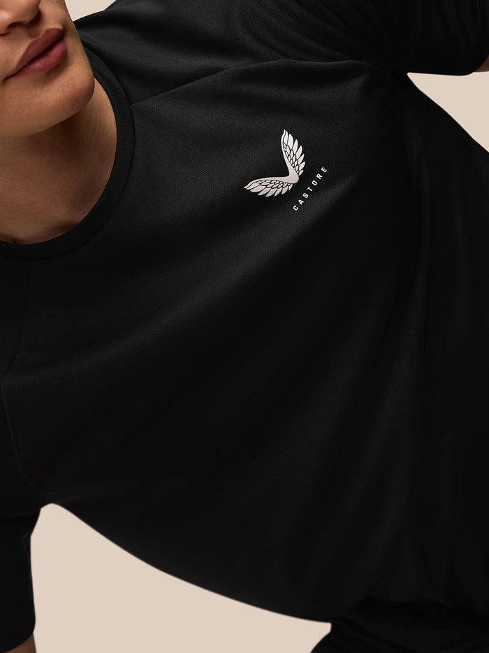 Close-up of white Castore wing logo on the chest of the black Adapt Training T-Shirt