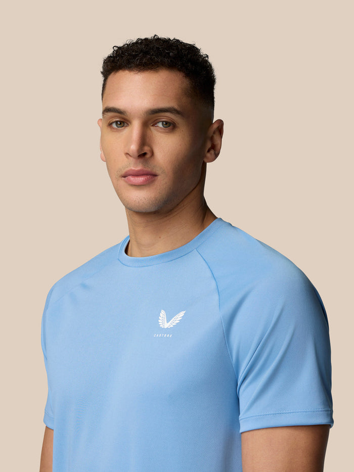 Front view of man wearing sky blue Adapt Training T-Shirt with Castore logo on chest.