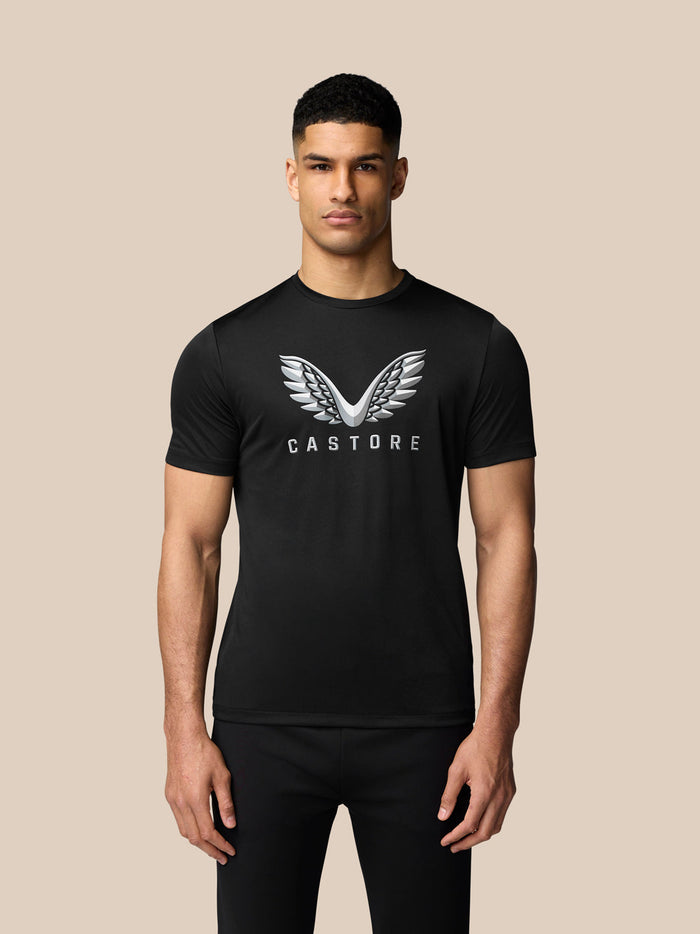 Male model wearing black graphic training T shirt with silver wing logo on chest