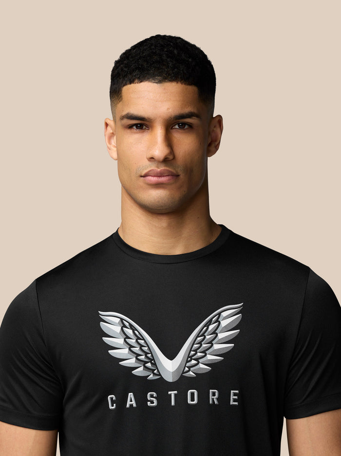 Male model wearing black graphic training T shirt with Castore wings logo on chest