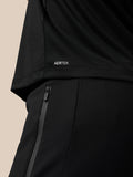 Close up of black athletic wear showing AERTEK branding at the back hem and a vertical zip on the shorts