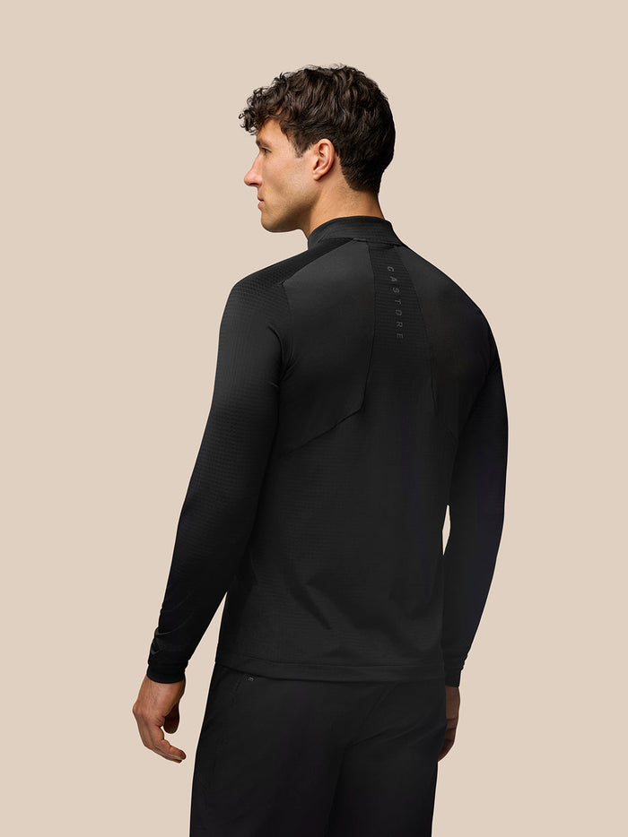 Back view of a man wearing black Apex Training Quarter Zip Top with vertical Castore branding along the back