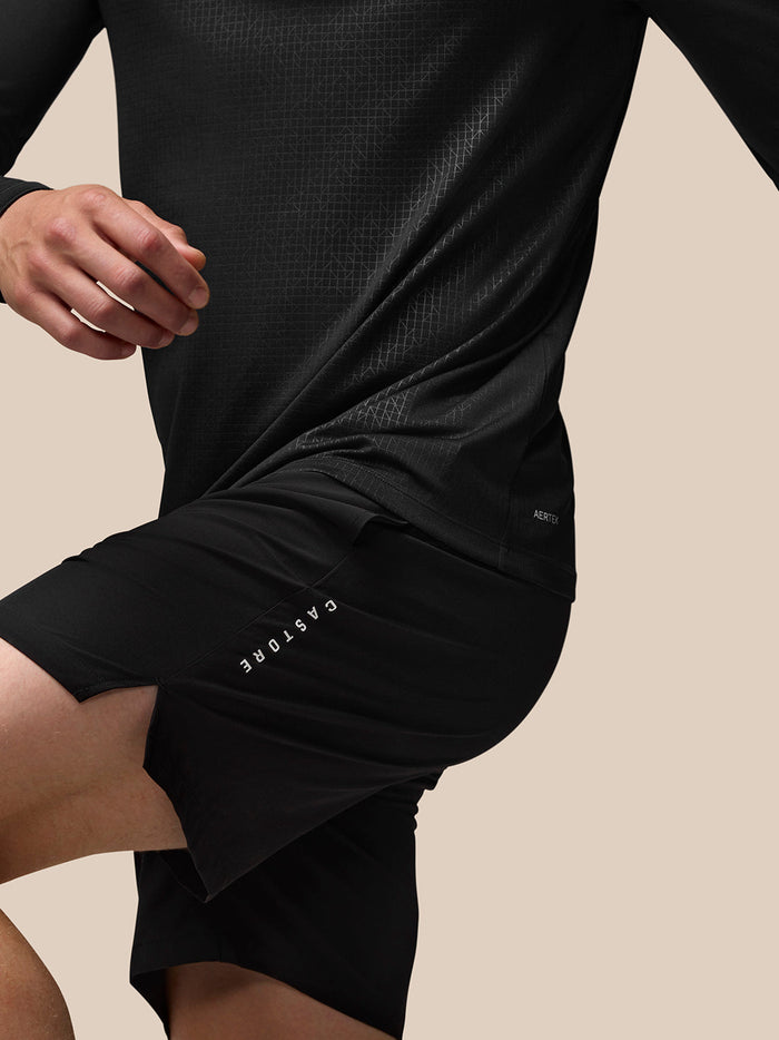 Back three-quarter view of model in black Adapt Print Quarter Zip Top with Aertek branding at the lower back.