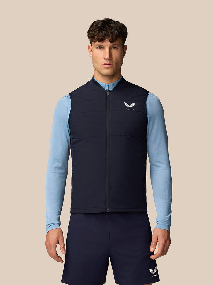 Male model wearing navy Apex Training Gilet with full length front zipper and Castore branding on the chest.