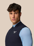 Three-quarter view of male model wearing navy Apex Training Gilet; chest Castore logo and front zip visible.