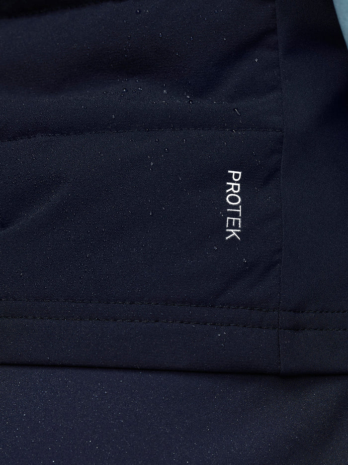 Close-up of navy gilet fabric with ProTek branding visible on the lower back