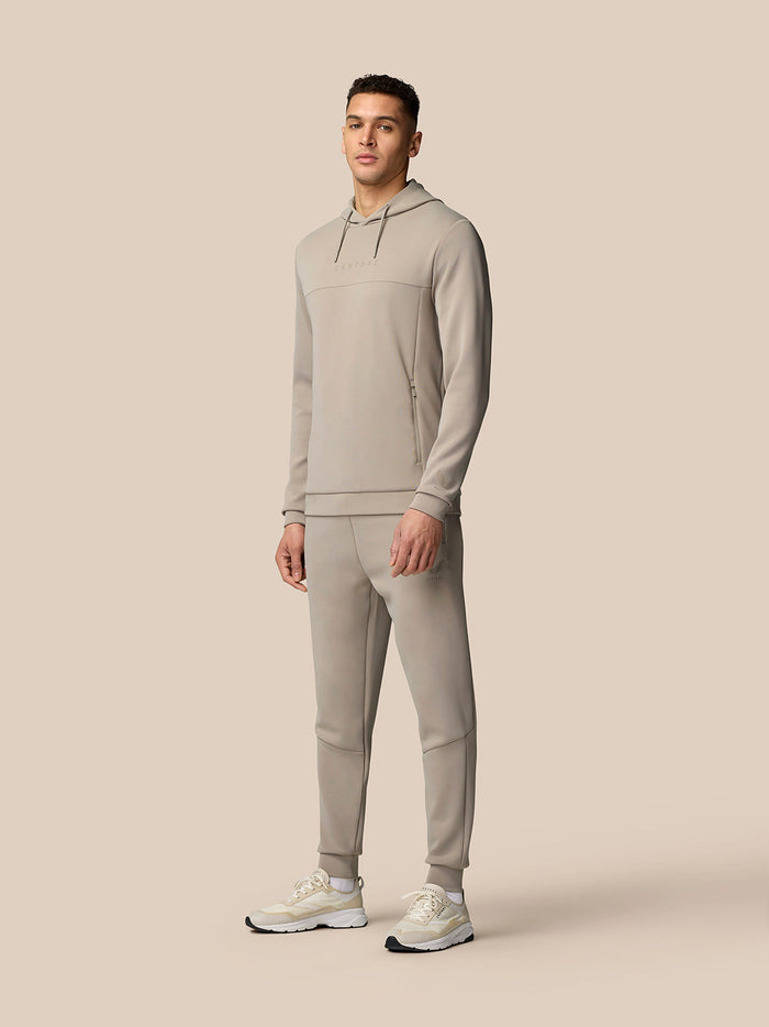 Close-up of beige Flex Lifestyle Joggers fabric with PROTEK branding and visible stitching