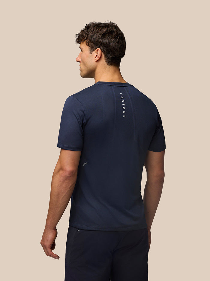 Back view of male model in Midnight Navy Apex Training T-Shirt showing vertical Castore branding down the back.