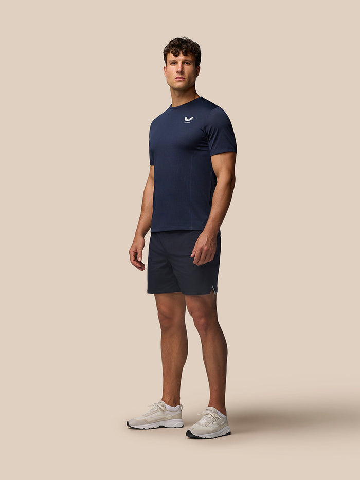 Male model in midnight navy Apex Training T Shirt with chest logo and matching shorts, full-body view.