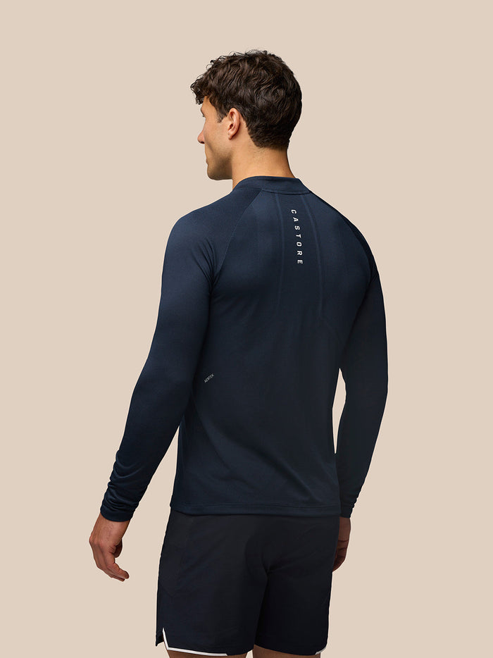 Back view of navy Apex Long Sleeve Engineered Knit Quarter Zip Top with vertical Castore branding along the back