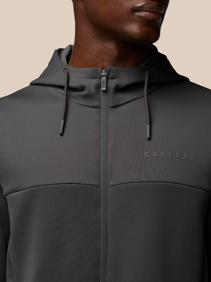 Close-up of charcoal Flex Lifestyle Full Zip jacket showing hood drawcords and chest branding.