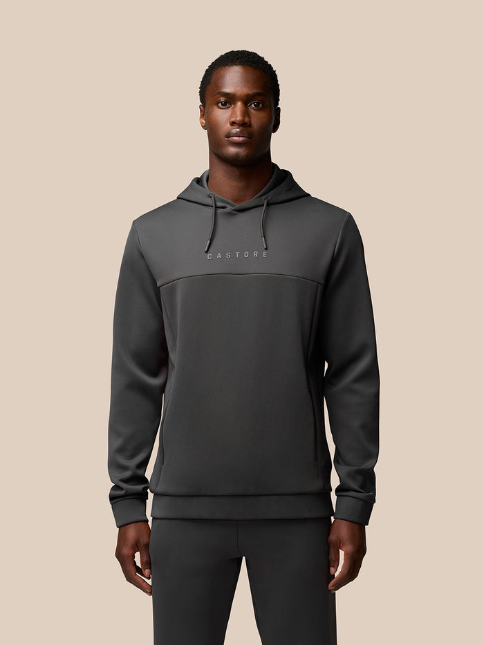 Front view of charcoal Flex Lifestyle Hoodie on a model showcasing the two tone chest panel and Castore branding
