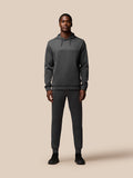 Full body shot of a man in charcoal Flex Lifestyle Hoodie with matching joggers and CASTORE branding on chest