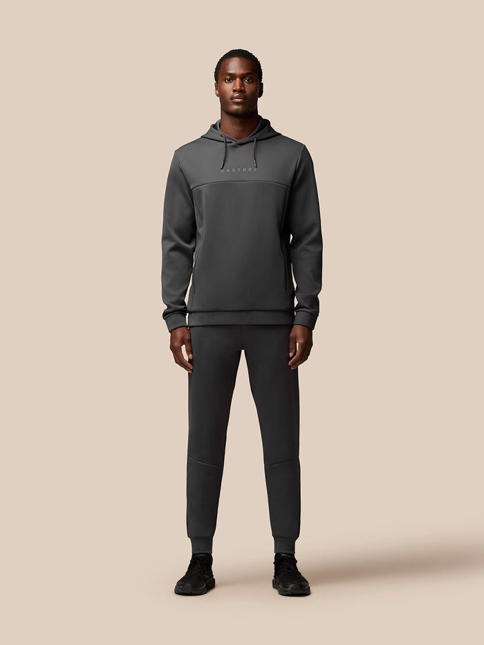 Full body shot of a man in charcoal Flex Lifestyle Hoodie with matching joggers and CASTORE branding on chest