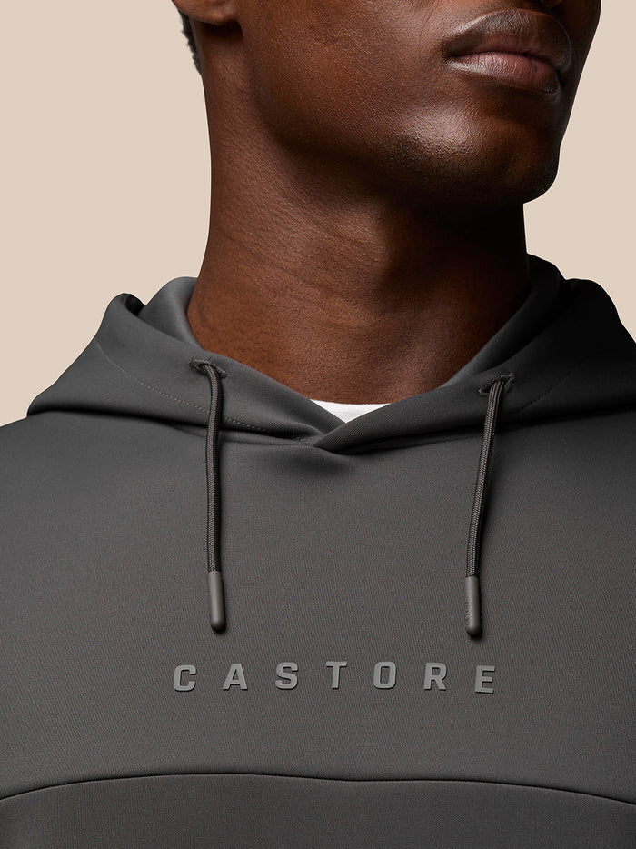 Close up of a man wearing the charcoal Flex Lifestyle Hoodie showing CASTORE logo on the chest