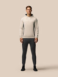 Beige hoodie sleeve close-up showing embossed Castore wing logo and a side zip pocket.