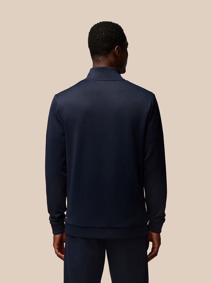 Back view of a man in a navy Flex Quarter Zip top showing the high collar and seamless back design