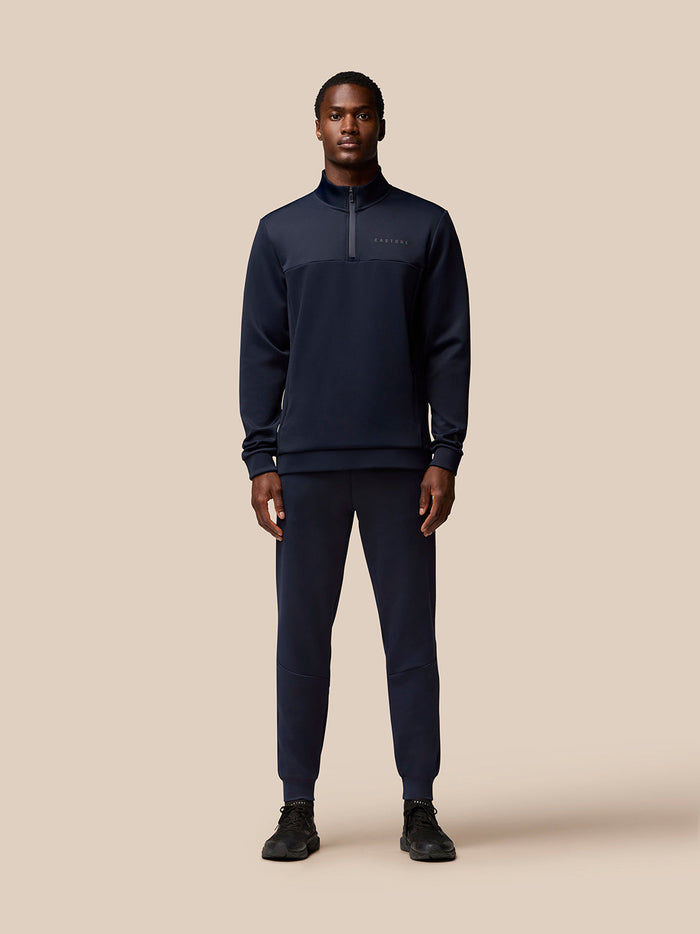 Male model in navy Flex Lifestyle Quarter Zip top with Protek finish and zip pockets