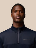 Close-up of a man wearing a navy Castore Flex Lifestyle Quarter Zip with center zipper and left chest branding