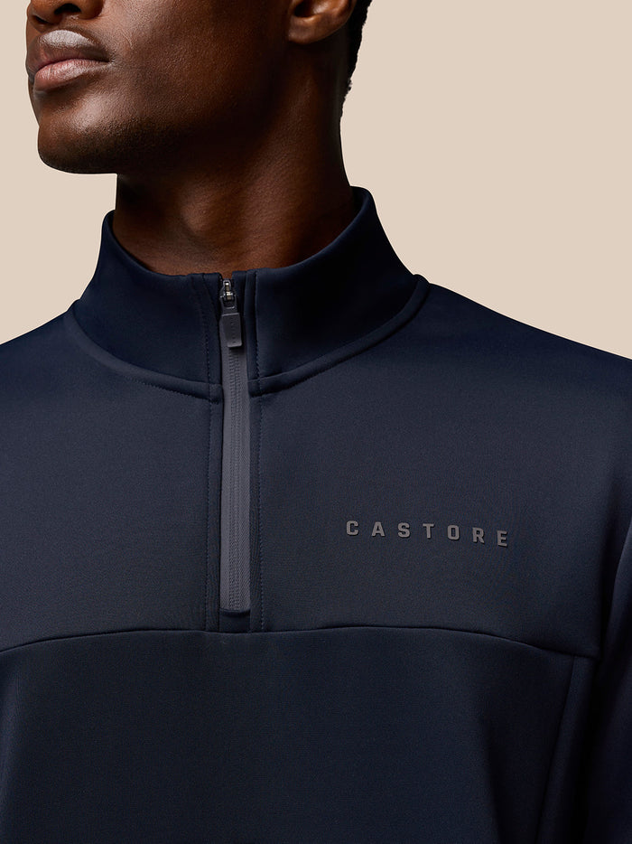 Close-up of navy Castore Flex Quarter Zip collar showing the zipper and chest logo