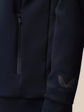 Detail of the navy quarter zip sleeve with the Castore wing logo near the cuff