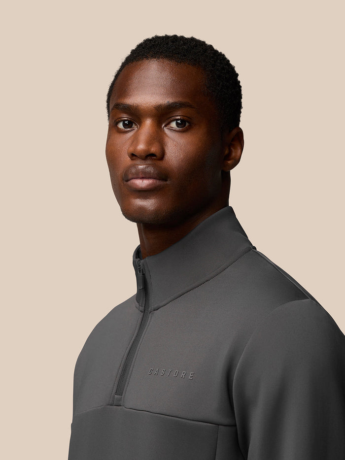 Three-quarter view of male model in charcoal Flex Sweatshirt with Castore logo on chest