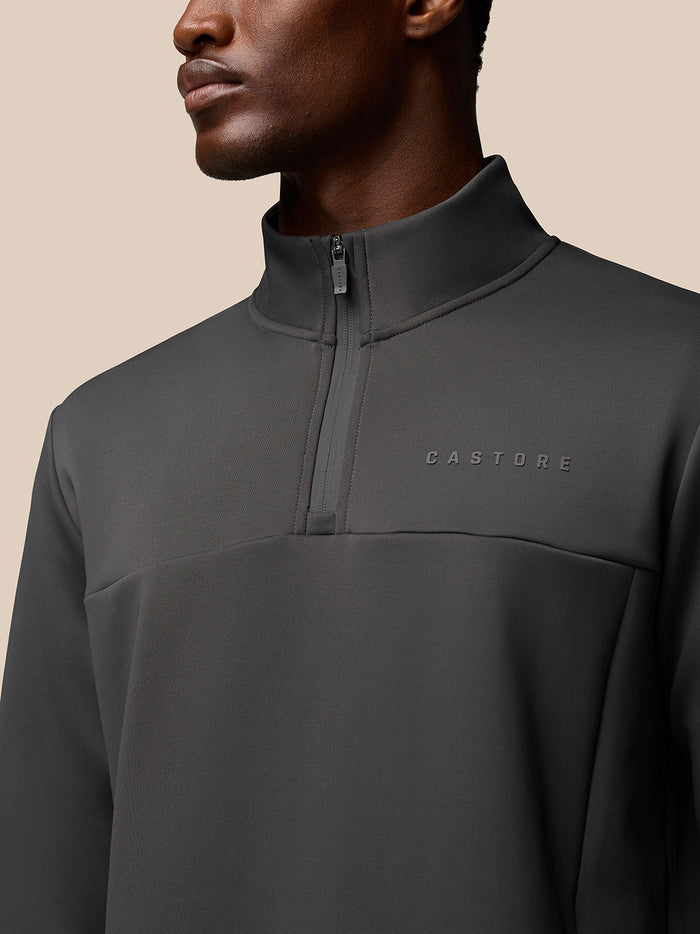 Close up of a man wearing a charcoal Flex Sweatshirt quarter zip with a high collar and front zipper.