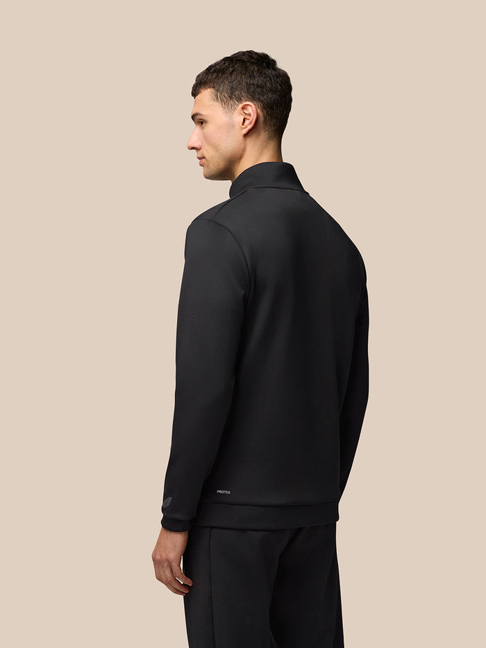 Back view of male model in black Flex Lifestyle 1/4 Zip top showing scuba fabric and clean silhouette