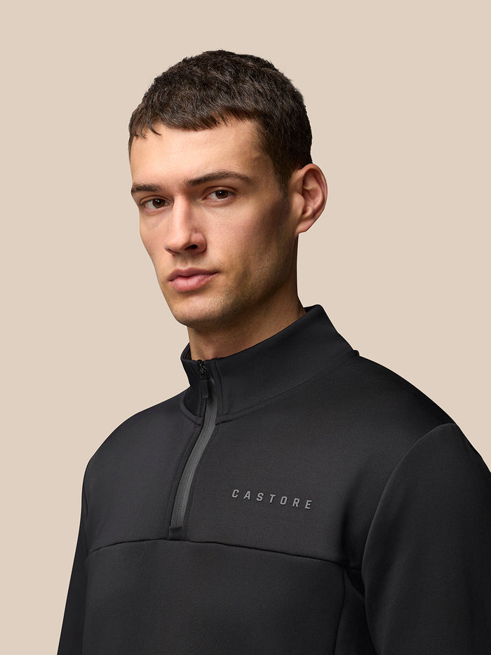 Front view of black Flex Lifestyle 1/4 Zip top featuring a chest zip and Castore logo on the left chest