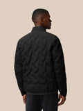 Back view of black padded jacket with chevron quilting and stand collar on a model