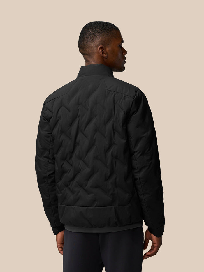 Back view of black padded jacket with chevron quilting and stand collar on a model