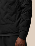 Close-up of black padded jacket fabric showing quilted texture and sleeve area