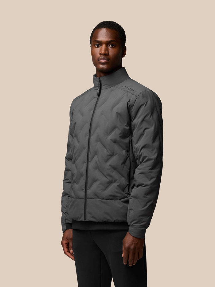 Male model wearing charcoal Quilts Lifestyle Jacket with stand collar and zip front