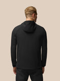 Back view of a model wearing a black Flex Winterised Jacket with a hood and subtle grid texture.