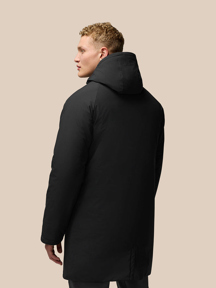 Back view of black longline insulated jacket with hood on a model.