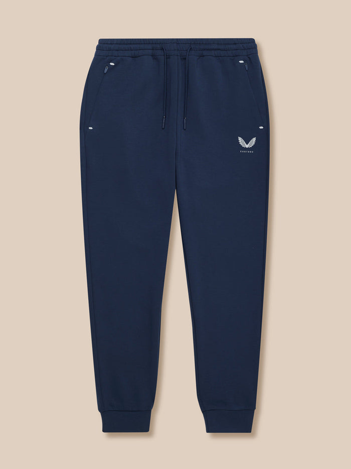 Full view of navy Travel Lifestyle Joggers laid flat showing drawstring waist and Castore logo on thigh