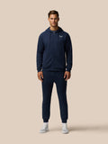 Male model in navy zip hoodie and matching Travel Lifestyle Joggers for a coordinated athleisure look.