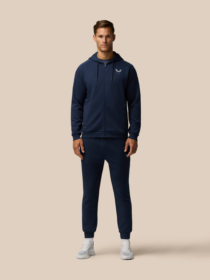 Male model in navy zip hoodie and matching Travel Lifestyle Joggers for a coordinated athleisure look.
