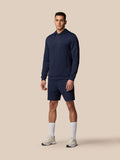 Male model wearing midnight navy Flex Lifestyle Shorts with a matching navy hoodie on a beige studio backdrop