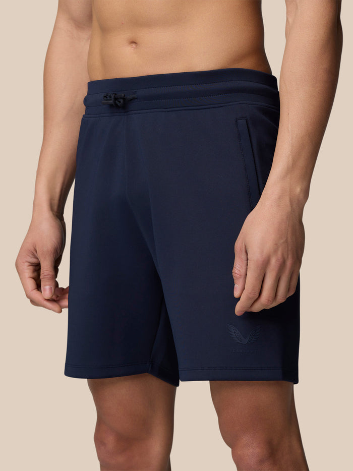 Lower body shot of a man wearing navy Flex Lifestyle Shorts with drawstring waistband and zip pockets